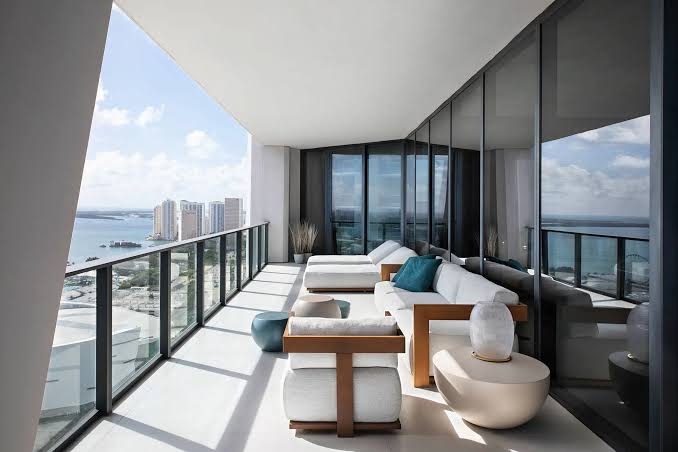 A tidy high-rise balcony lounge overlooking the water